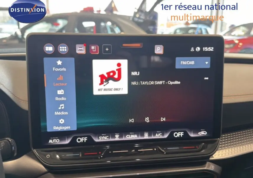 Écran tactile central du tableau de bord de la CUPRA LEON ST 2025, affichant la radio NRJ avec interface moderne.