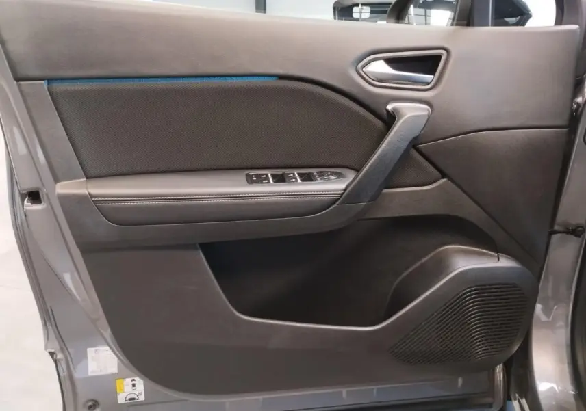 Vue latérale de la porte avant gauche gris cassiopée du Renault Symbioz avec commandes de vitres et haut-parleur intégré.