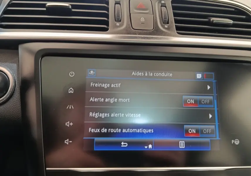 Écran tactile central du tableau de bord du Renault Kadjar blanc, affichant les aides à la conduite activées.