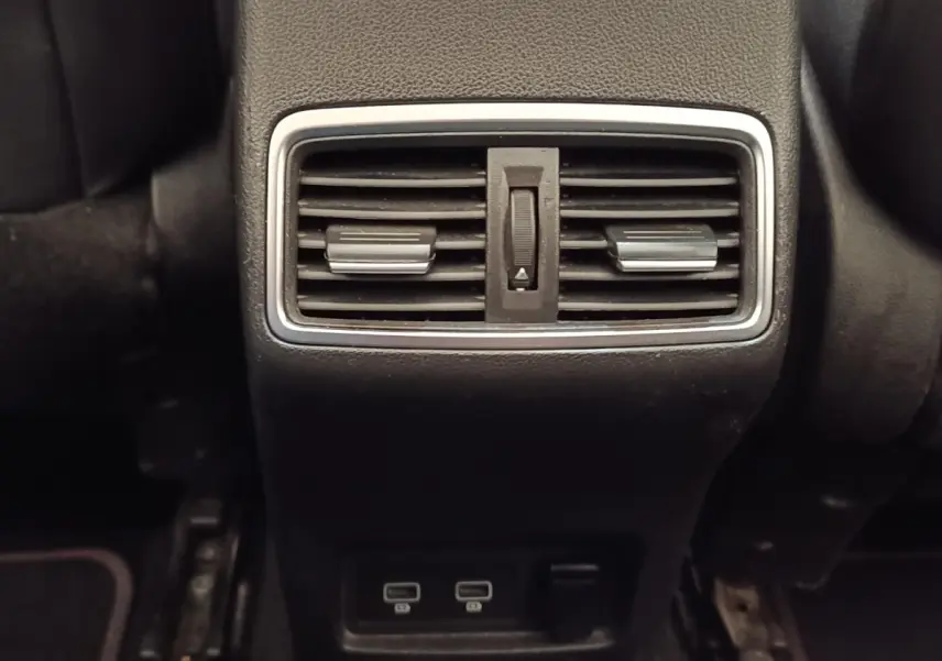 Gros plan sur la sortie d'air arrière et les ports USB du Renault Kadjar Black Edition blanc, intérieur noir.