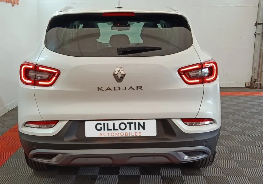 Vue arrière d'un Renault Kadjar blanc avec feux LED allumés dans un garage intérieur.