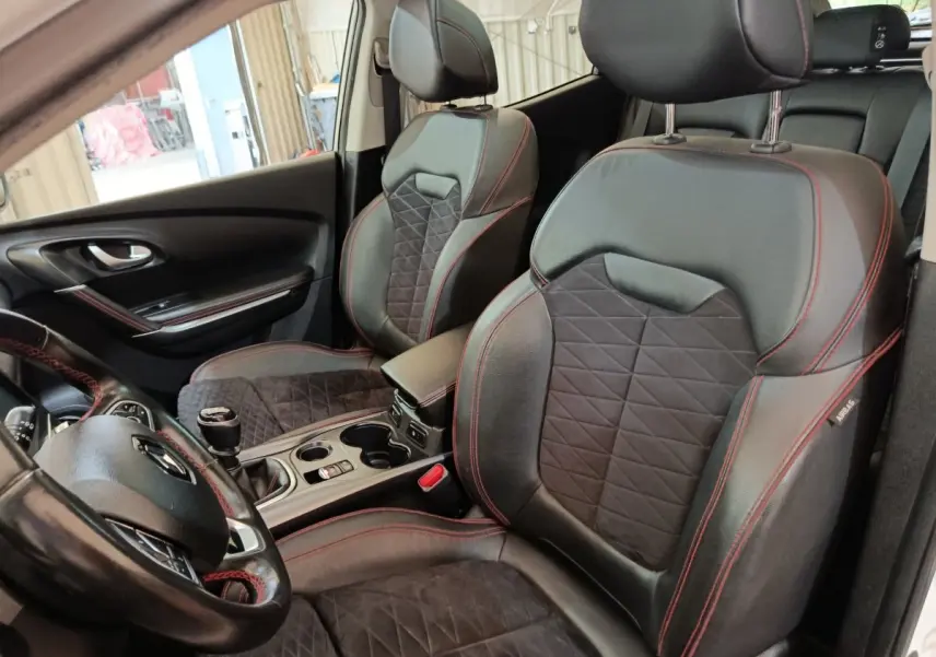 Vue intérieure côté conducteur du Renault Kadjar Black Edition 2020, sièges cuir noir avec surpiqûres rouges et volant cuir.
