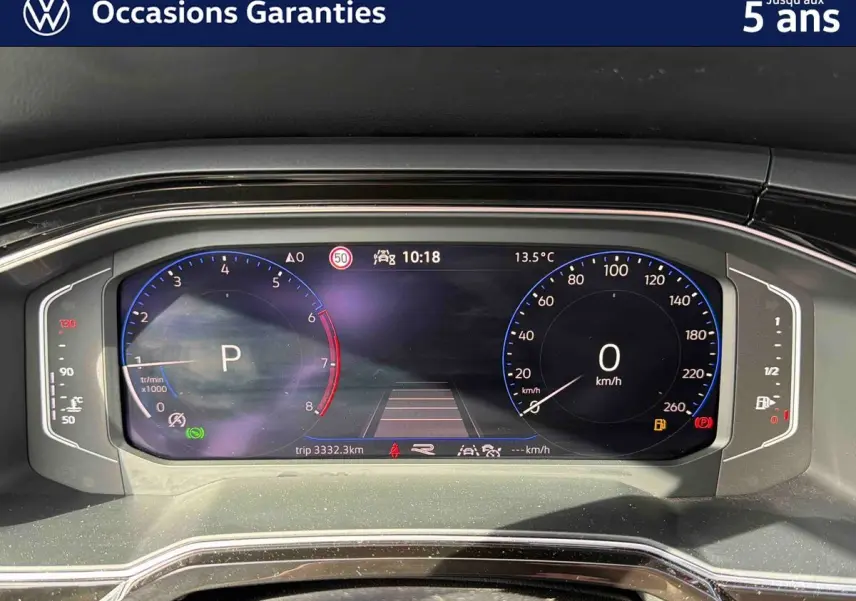 Tableau de bord digital du Volkswagen Taigo gris, affichage vitesse et compte-tours en vue frontale rapprochée.