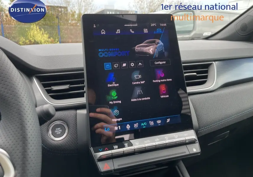 Vue intérieure centrée sur l’écran tactile vertical du tableau de bord du Renault Symbioz gris cassiopée, avec détails du volant et bouton start visible.