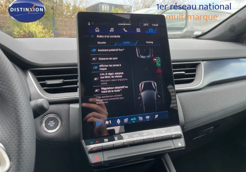 Vue intérieure centrée sur l'écran tactile vertical du tableau de bord du Renault Symbioz gris, avec détails des aides à la conduite.