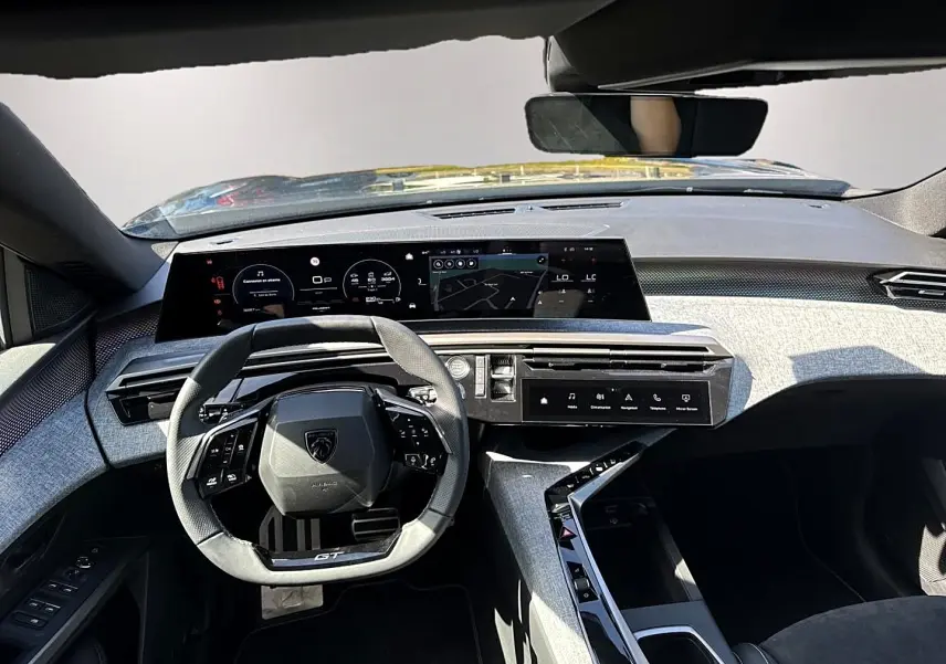 Vue intérieure avant du Peugeot 5008 Hybrid 145 GT e-dcs6 2025, tableau de bord moderne avec volant compact et écran large.