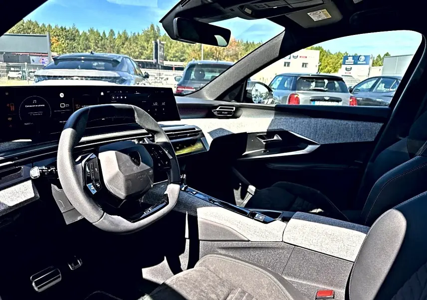Intérieur du Peugeot 5008 Hybrid 145 GT vu côté conducteur, volant multifonction et tableau de bord numérique.