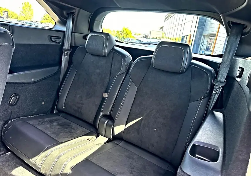 Vue intérieure arrière montrant les deux sièges supplémentaires noirs avec surpiqûres blanches du Peugeot 5008 Hybrid 145 GT 2025.