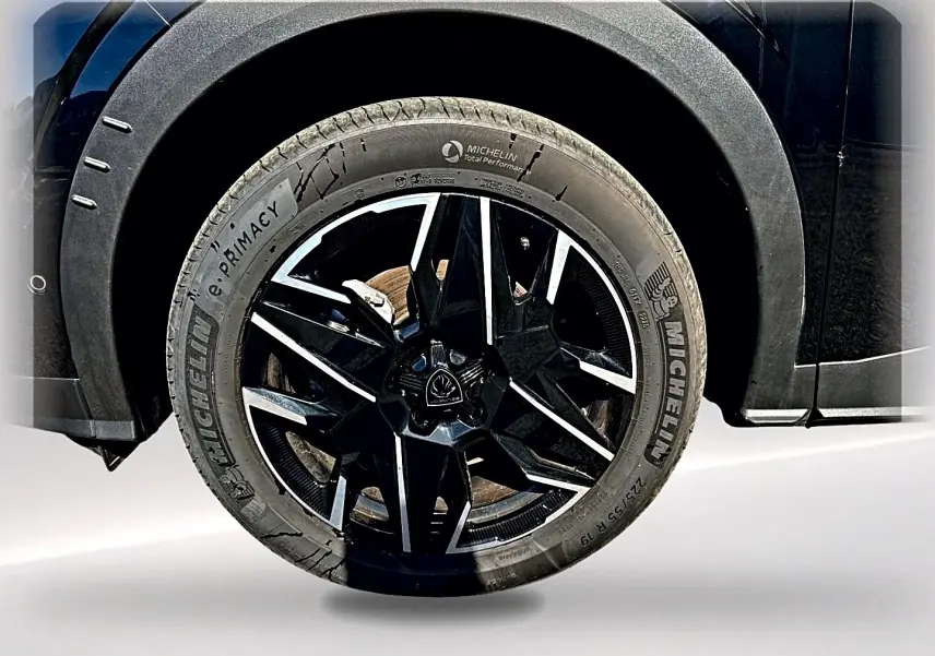Gros plan sur la roue avant droite noire avec jante alu noire et argentée du Peugeot 5008 Hybrid 145 GT e-dcs6 noir.