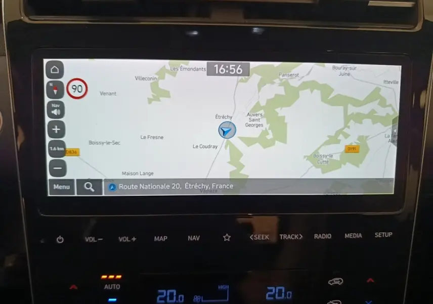 Écran tactile central du Hyundai Tucson bleu 2021 affichant la navigation GPS avec carte et commandes climatisation digitales.