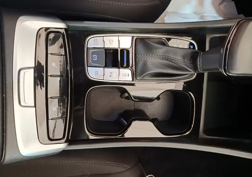 Vue rapprochée de la console centrale noire du Hyundai Tucson bleu 2021 avec levier de vitesses et commandes tactiles.