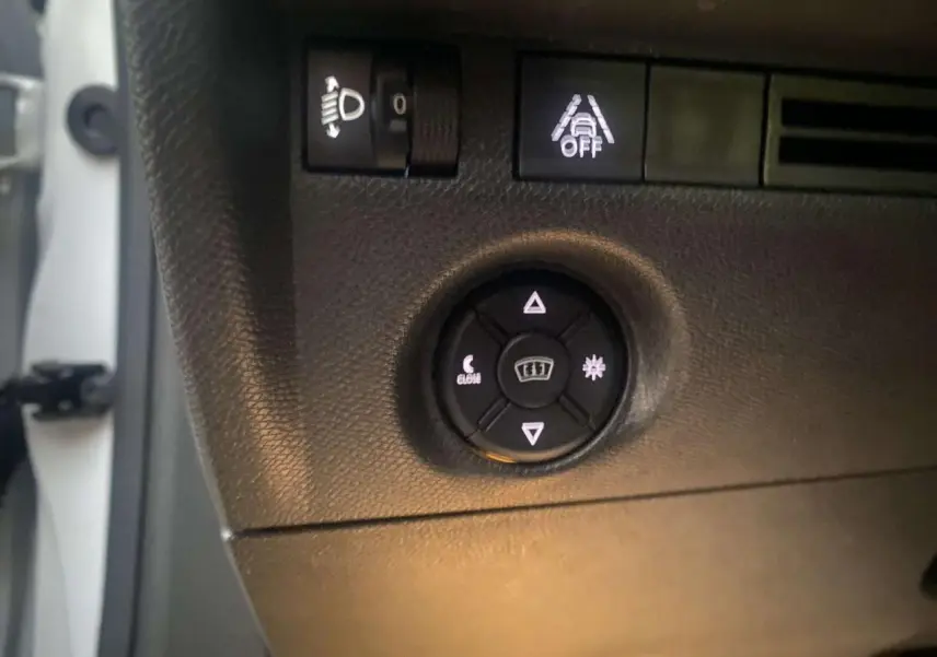 Gros plan sur les commandes d'éclairage et d'aide à la conduite du tableau de bord d'une Citroën C4 blanche de 2021.