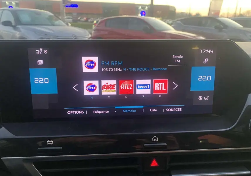 Écran tactile central de la Citroën C4 blanche de 2021 affichant la radio FM et la température à 22°C.