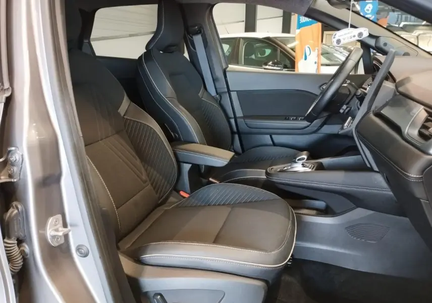 Vue intérieure côté gauche des sièges avant noirs avec surpiqûres blanches du Renault Symbioz 2025 Gris Cassiopée.