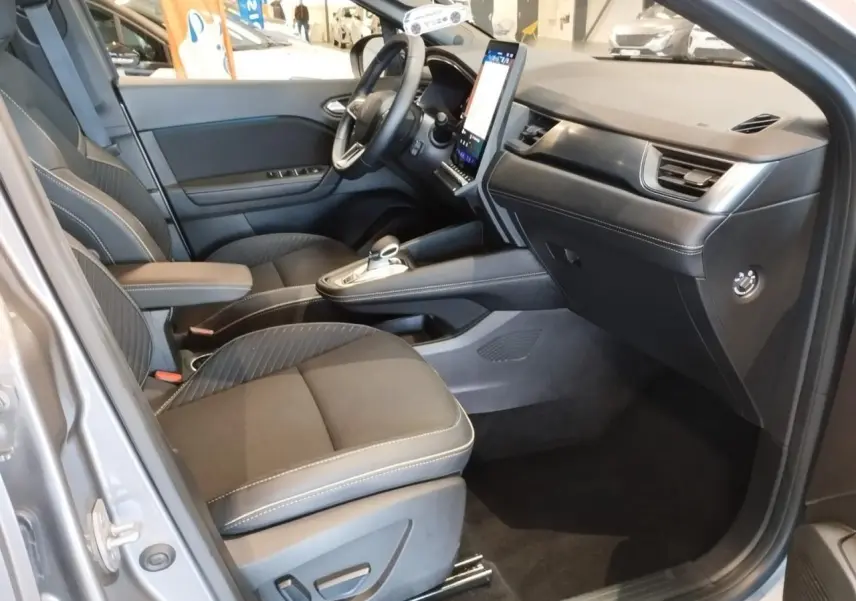 Vue intérieure côté conducteur de la Renault SYMBIOZ 2025 gris Cassiopée avec tableau de bord moderne et écran vertical.