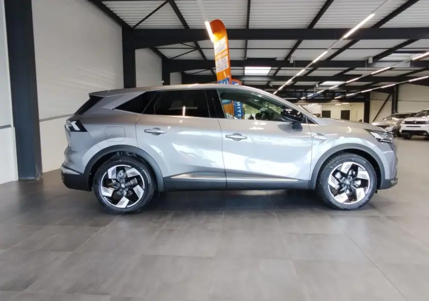 Renault Symbioz gris Cassiopée vue de profil côté gauche en intérieur avec jantes alliage distinctives.