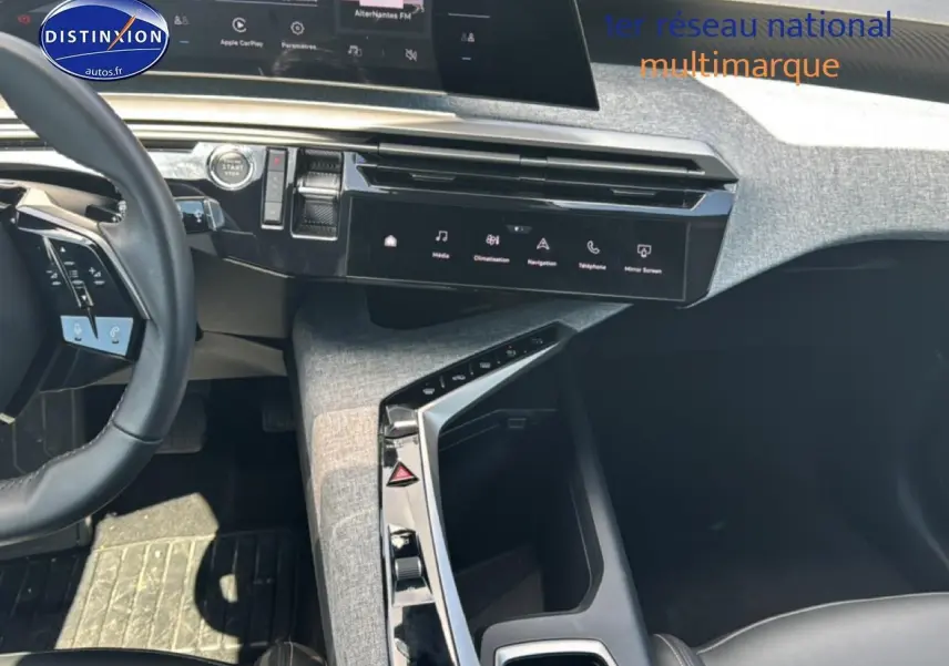 Vue intérieure du tableau de bord et console centrale du Peugeot 5008 Hybrid 145 allure e-dcs6 avec sellerie noire et finitions grises.
