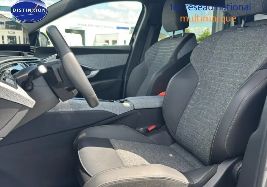 Vue intérieure côté conducteur du Peugeot 5008 Hybrid 145 allure e-dcs6 2025 avec sièges tissu gris et cuir noir.