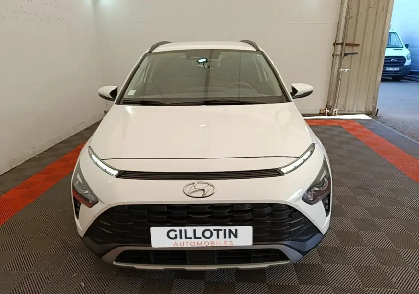 Vue avant d'un Hyundai Bayon blanc avec calandre noire et feux LED fins dans un garage.