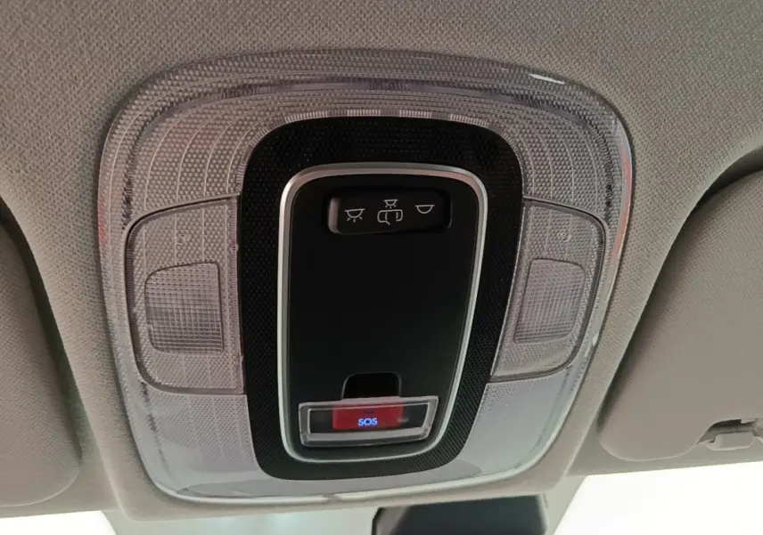 Vue en plongée sur le plafonnier intérieur avec bouton SOS et commandes d’éclairage dans un Hyundai Bayon blanc.