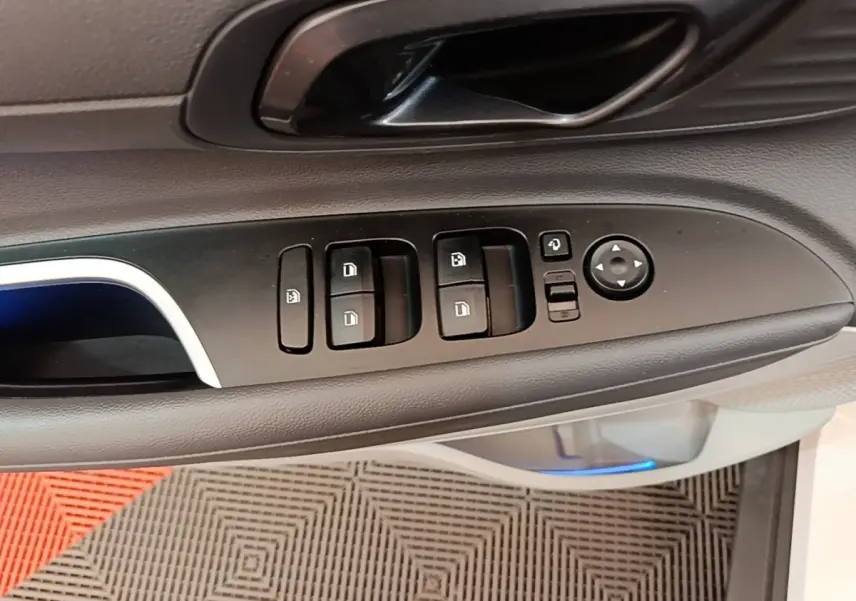 Gros plan sur la commande de lève-vitres et rétroviseurs côté conducteur intérieur d’une Hyundai Bayon blanche 2024.