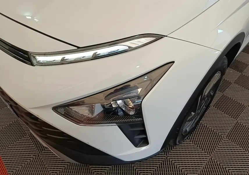 Gros plan sur l'avant droit blanc du Hyundai Bayon 2024, mettant en valeur les phares LED et la calandre noire.