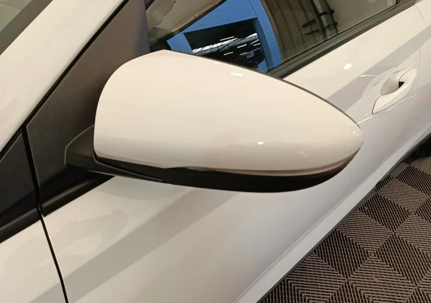 Rétroviseur côté conducteur blanc de Hyundai Bayon 2024, vue rapprochée sur la portière et poignée.