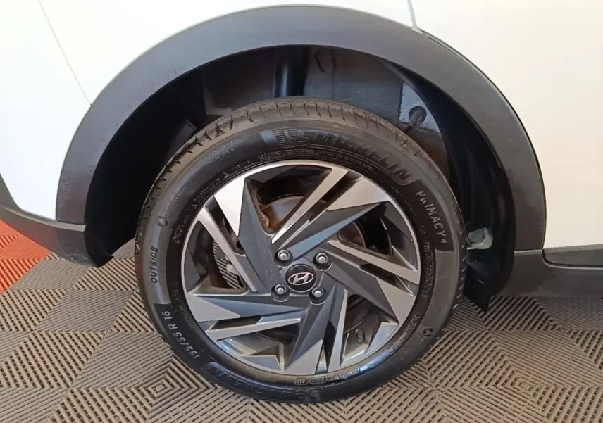 Gros plan sur la roue arrière droite d’une Hyundai Bayon blanche 2024 avec jante alliage bicolore et pneu Michelin.