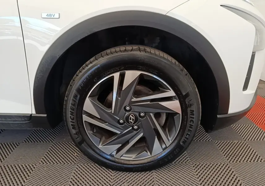 Gros plan sur la roue avant droite blanche du Hyundai Bayon 2024 avec jante alliage et badge 48V visible sur l'aile.