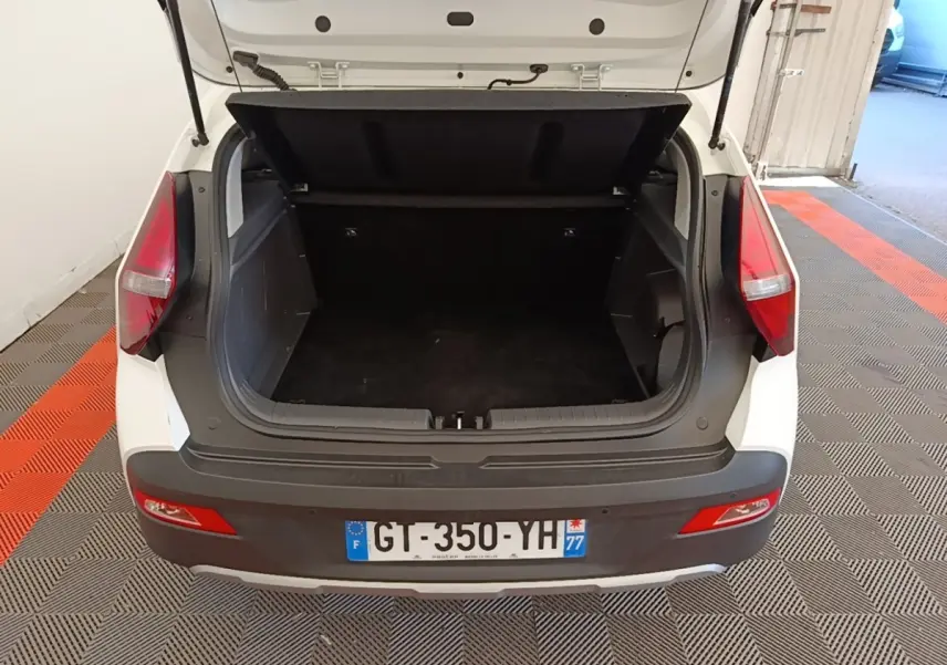 Vue arrière ouverte du coffre blanc d'une Hyundai Bayon 2024, soulignant l'espace de chargement vide et les feux arrière rouges.