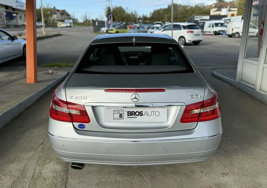 Vue arrière d'une Mercedes Classe E 250 CDI gris métallisé avec feux rouges et logo central visible.
