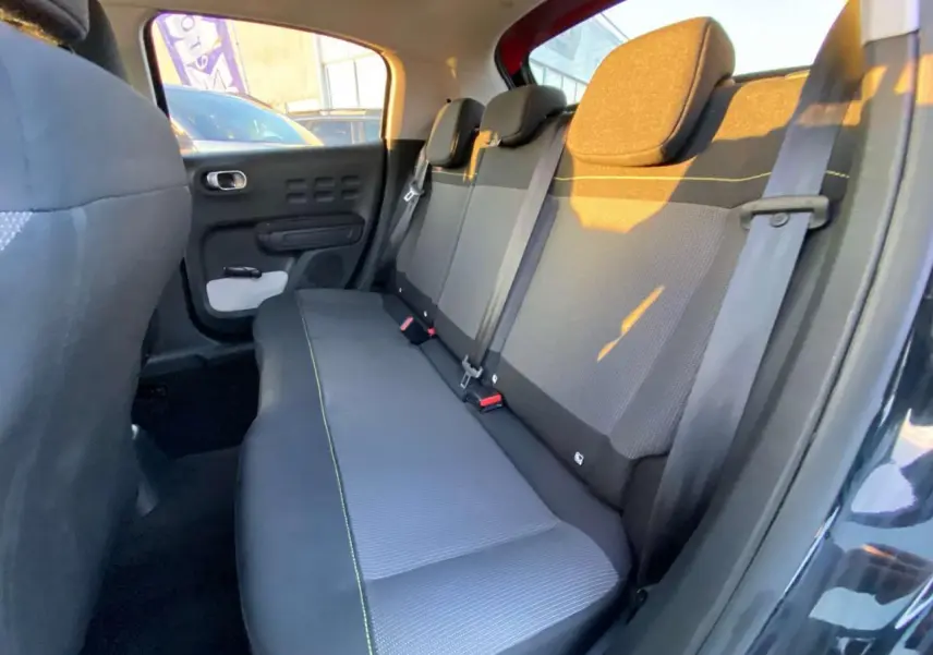 Banquette arrière en tissu gris avec surpiqûres jaunes, vue côté droit dans une Citroën C3 Shine 2023 toit rouge.