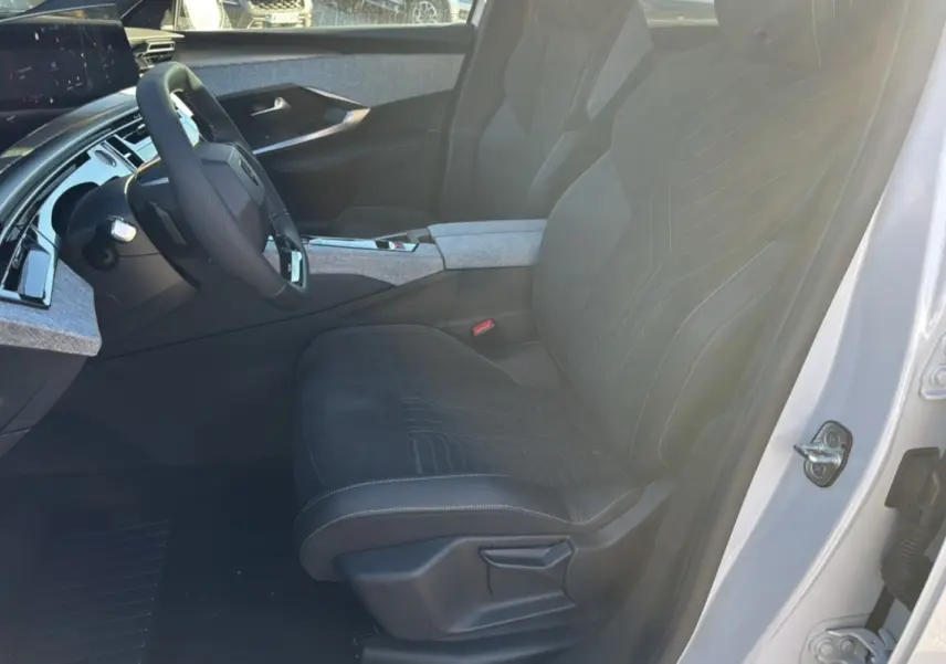 Intérieur du Peugeot 3008 Hybrid 2024 vu côté conducteur, sièges noirs avec surpiqûres et détails gris clair.