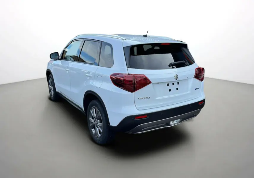 Suzuki Vitara 2025 blanc nacré vu en 3/4 arrière droit, avec vitres teintées et logo AllGrip visible.
