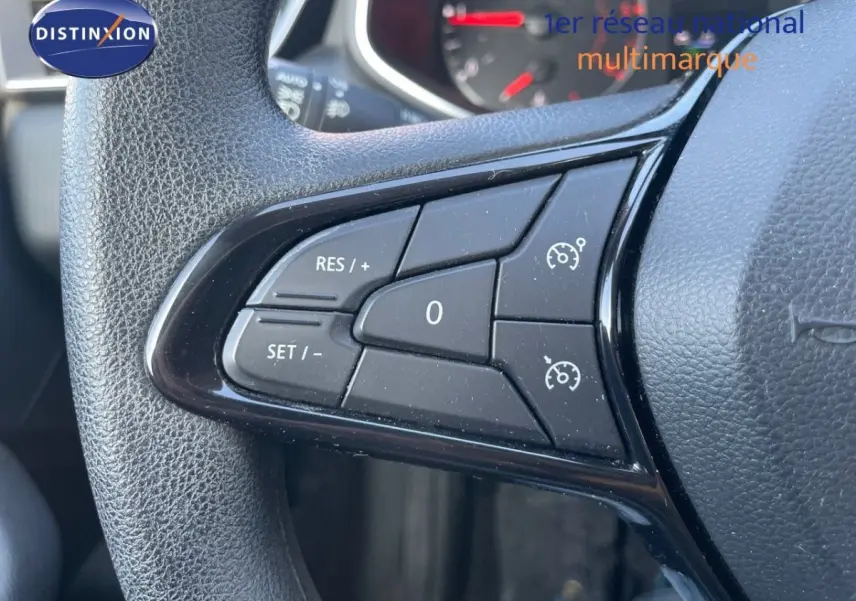 Gros plan sur les commandes de régulateur de vitesse au volant d'une Renault Clio blanche de 2020.