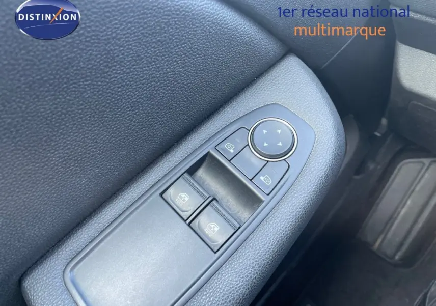 Gros plan sur la commande des vitres côté conducteur de la Renault Clio blanche, intérieur noir.