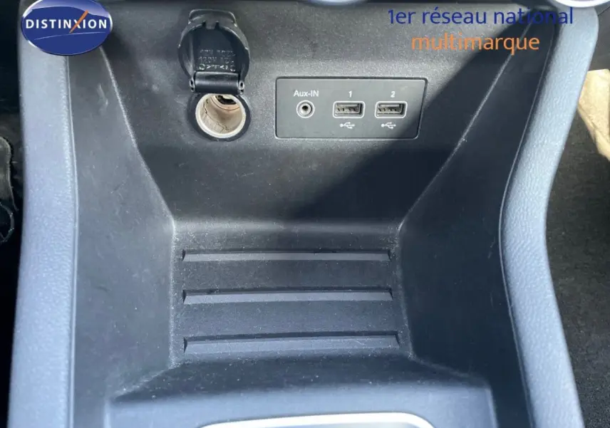 Prise 12V et ports USB visibles dans la console centrale noire d'une Renault Clio blanche version Air Nav Blue dCi 2020.