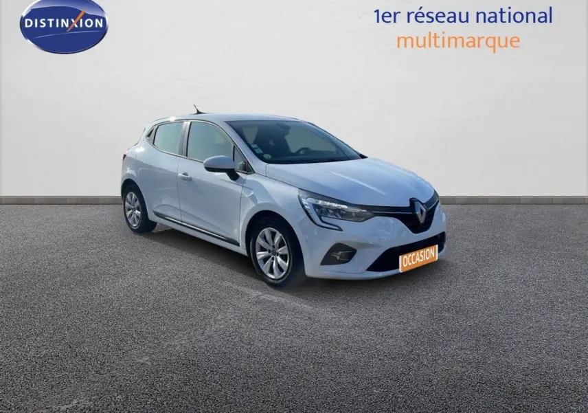 Renault Clio blanche vue 3/4 avant droit sur sol gris, avec phares LED et logo Distinxion en arrière-plan.