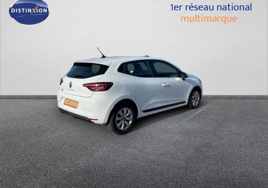Renault Clio blanche vue 3/4 arrière côté droit, stationnée devant un mur blanc avec logo Distinxion.