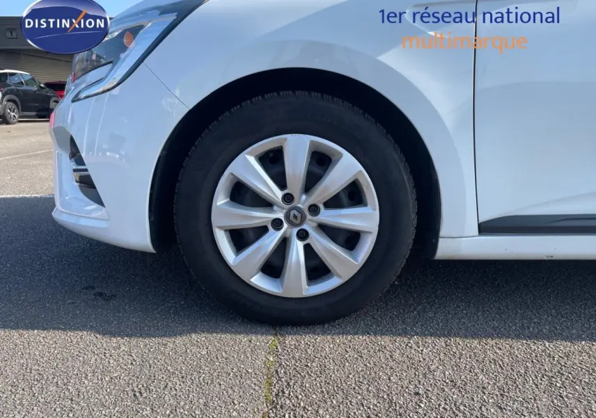 Gros plan sur la roue avant gauche d'une Renault Clio blanche 2020, avec jante alliage et logo Renault visible.
