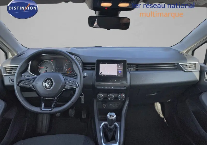 Tableau de bord et volant noir d'une Renault Clio 2020, vue frontale centrée sur l'écran tactile et la boîte manuelle.