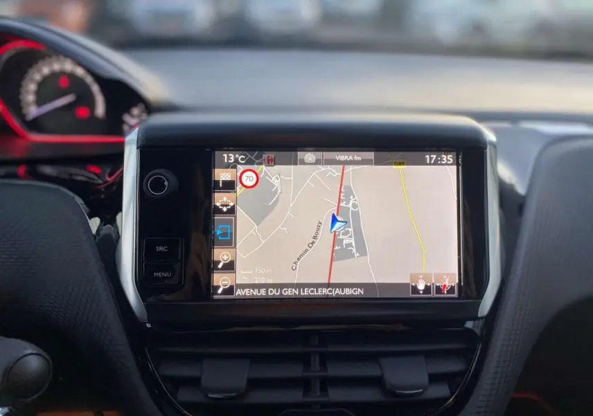 Vue rapprochée de l'écran tactile central avec navigation GPS dans l'habitacle d'une Peugeot 2008 blanche de 2016.