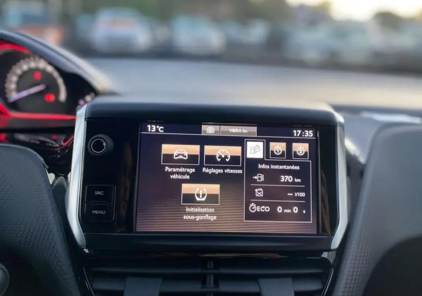 Vue intérieure centrée sur l'écran tactile du tableau de bord du Peugeot 2008 blanc GT Line de 2016.