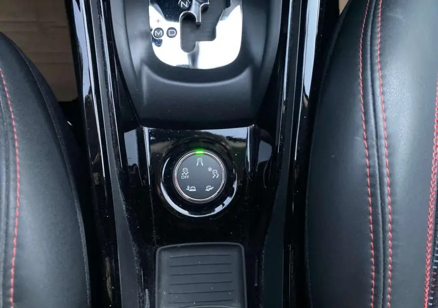 Gros plan sur la console centrale noire du Peugeot 2008 blanc 2016, avec levier de boîte auto et bouton de modes de conduite.