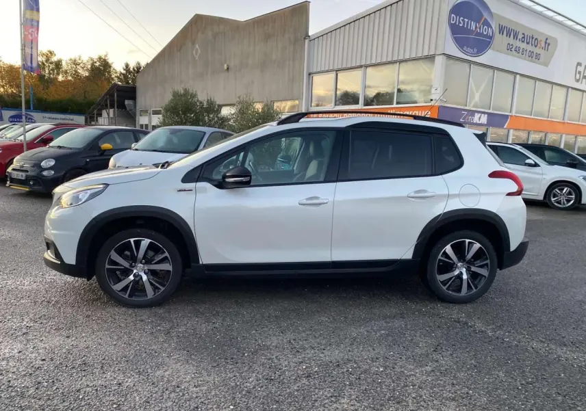 Profil côté gauche d'un Peugeot 2008 blanc GT Line 2016 avec jantes alliage et toit noir sur parking extérieur.