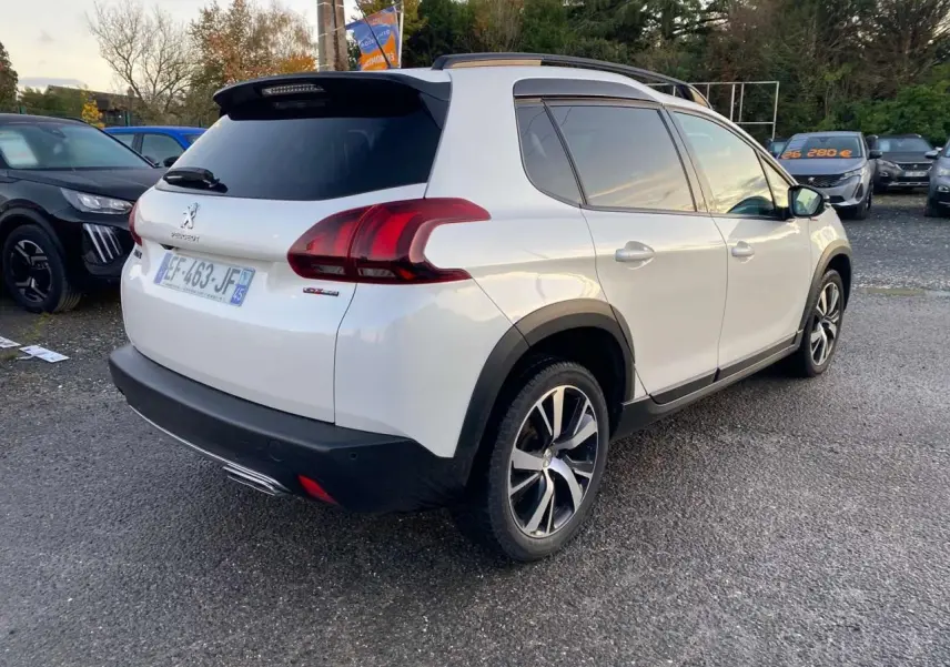 Peugeot 2008 blanc en 3/4 arrière droit, version GT Line avec jantes alliage et toit panoramique visible.