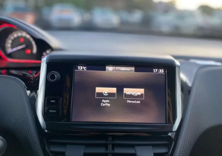 Écran tactile central du tableau de bord du Peugeot 2008 GT Line 2016, affichant Apple CarPlay et MirrorLink.