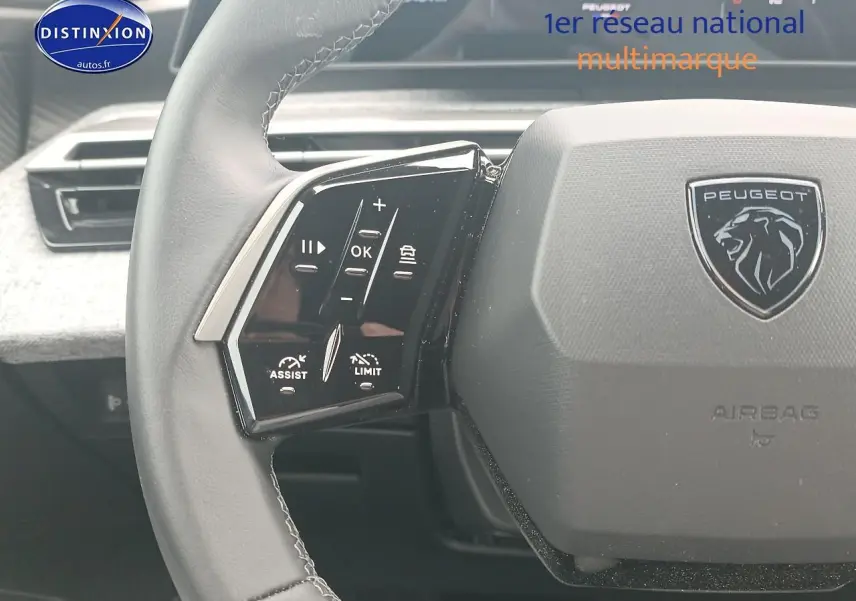 Vue rapprochée du volant cuir multifonction gris du Peugeot 3008 1.2 hybrid 145 allure e-dcs6 avec logo lion central.