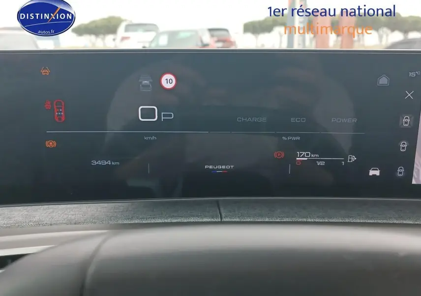 Tableau de bord numérique du Peugeot 3008 gris Artense, affichant la vitesse, autonomie et alertes, vue de face depuis le siège conducteur.