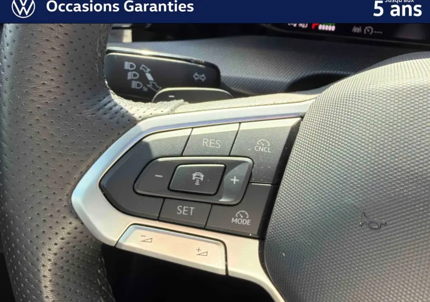Gros plan sur le volant sport multifonction en cuir de la Volkswagen Golf 1.5 eHybrid 2025, avec commandes intégrées.